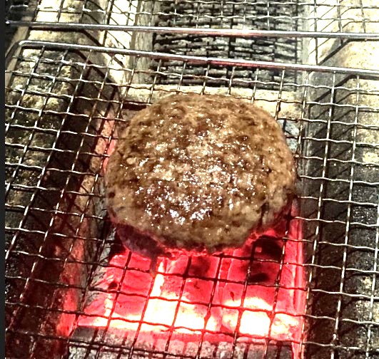 炭火焼ハンバーグ：網の熱で蒸しているハンバーグ